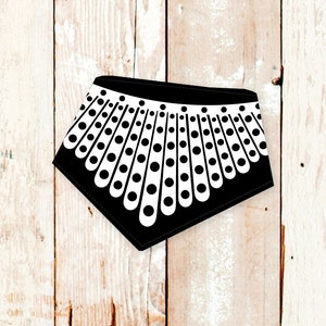 May include: Black and white dog bandana with a design resembling a judge's collar.