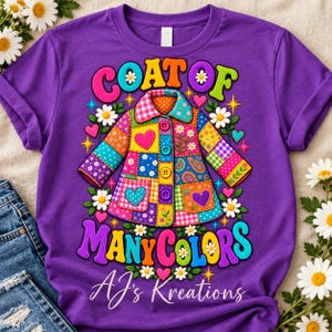 May include: A purple short-sleeved t-shirt featuring a graphic of a colorful patchwork coat with buttons and pockets. The text reads COAT OF MANY COLORS and AJ's Kreations, surrounded by daisies, hearts, and star shapes in vibrant hues.