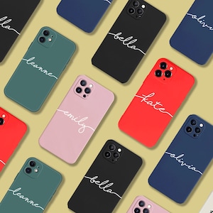 May include: A selection of coloured phone cases, including black, red, pink, green, and navy blue. Each case is personalised with a name in white script. The cases are designed to fit a smartphone.