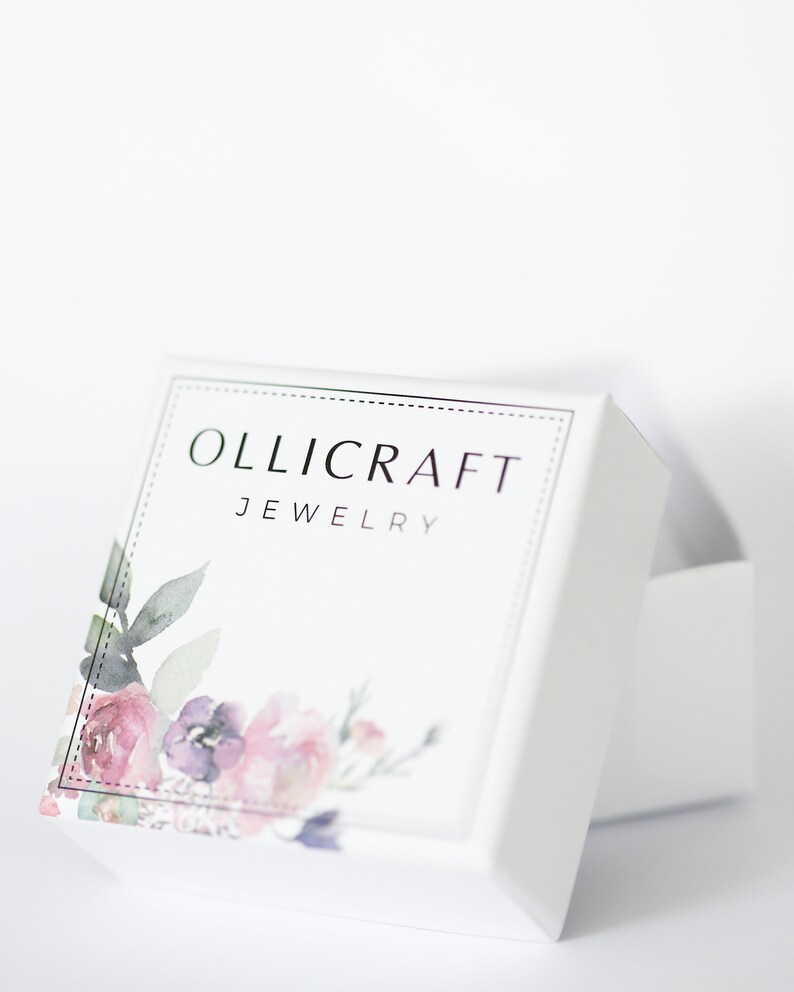 Puede incluir: Caja de joyer&iacute;a blanca con un dise&ntilde;o floral y el texto "OLLICRAFT JEWELRY" en la parte delantera.