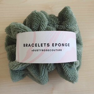 Puede incluir: Una esponja circular esponjosa de color verde con una etiqueta blanca que dice "BRACELETS EPONGE #DUSTYROSECOUTURE".