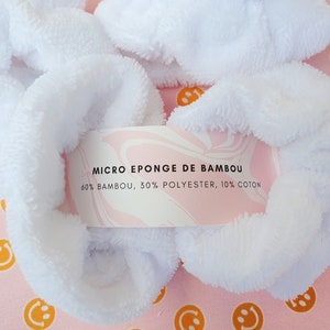 Puede incluir: Scrunchies blancos y esponjosos hechos de una mezcla de bamb&uacute;, poli&eacute;ster y algod&oacute;n. La etiqueta dice "MICRO EPONGE DE BAMBOU 60% BAMBOU, 30% POLYESTER, 10% COTON".