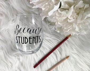May include: A clear glass wine glass with the text "Because Students." printed on the front.