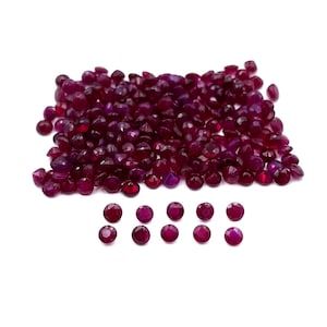 Könnte beinhalten: Ein großer Haufen rubinroter Edelsteine, darunter eine kleinere Gruppe der gleichen Edelsteine, die in einer Reihe angeordnet sind.