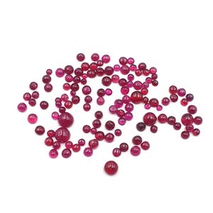 Peut inclure: Une dispersion de petites pierres précieuses rondes rouges. Les pierres précieuses sont de différentes nuances de rouge, du rose clair au rouge foncé.