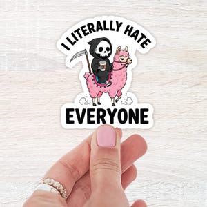 May include: A white sticker with the text "I literally hate everyone." The sticker features a cartoon Grim Reaper riding a pink llama and holding a coffee cup. The Grim Reaper has a skull face and is wearing a black robe.