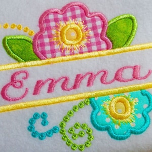 May include: Embroidered design featuring a pink and white gingham flower with a yellow center, green leaves, and a yellow banner with the name "Emma" in pink lettering.