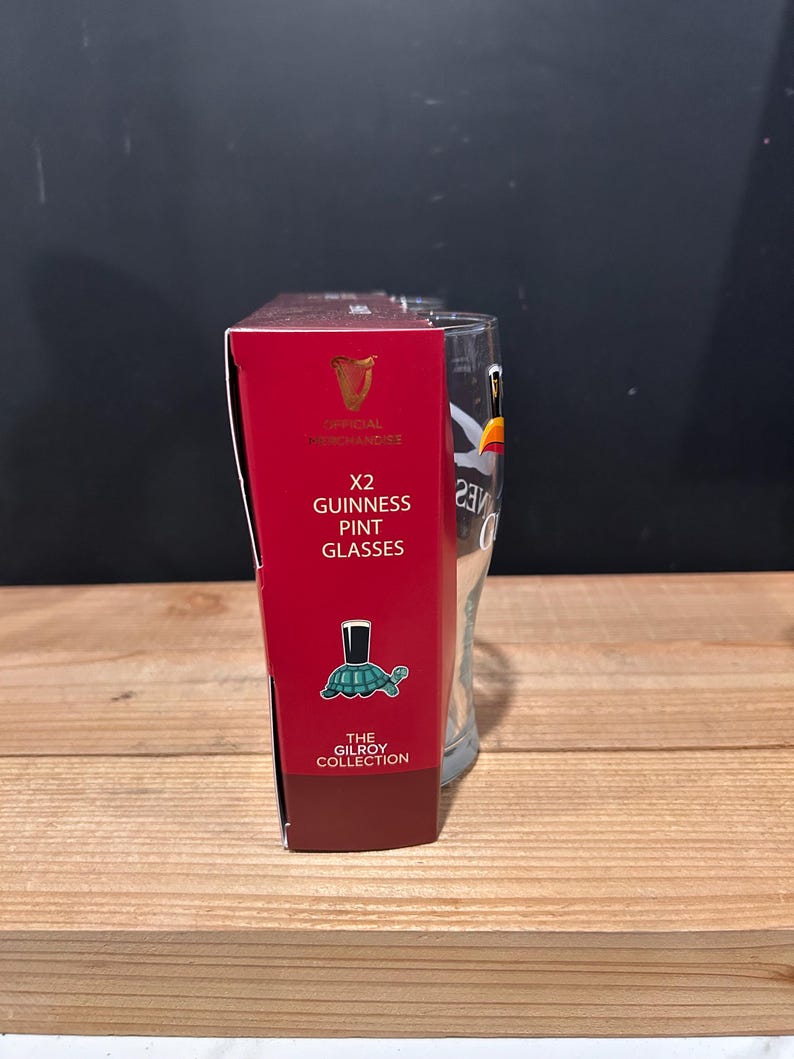 May include: A red box with the text "X2 Guinness Pint Glasses" next to a clear pint glass. The box has the Guinness logo and the words "Official Merchandise". The box also has a turtle illustration.