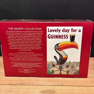 May include: A red box featuring a Guinness advertisement. The advertisement shows a toucan with a pint of Guinness on its beak, with the text "Lovely day for a Guinness". The box also has text about the Gilroy Collection.