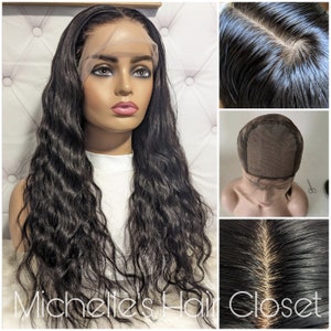 Może przedstawiać: Długa, falista, czarna peruka na głowie manekina. Peruka ma koronkowy przód i naturalnie wyglądającą linię włosów. Obraz zawiera zbliżenia czepka peruki i korzeni włosów. Tekst "Michelle's Hair Closet" jest widoczny.