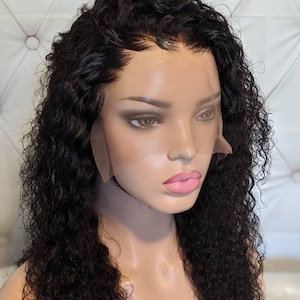 May include: A black human hair wig with a lace front and deep wave curls. The wig is styled on a mannequin head.
