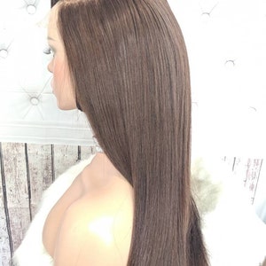 May include: A long, straight, brown human hair wig with a lace front. The wig is styled in a center part and falls to the shoulders.