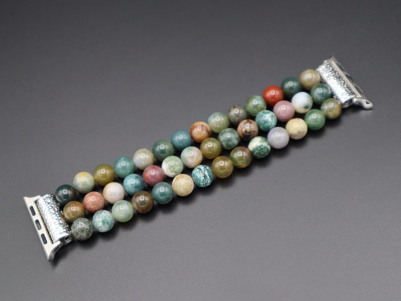 Puede incluir: Un brazalete de cuentas de &aacute;gata multicolor con cierre de metal plateado, dise&ntilde;ado para un Apple Watch.