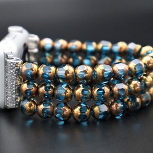 May include: A watch band made of blue and gold beads. The band is made of multiple strands of beads, and it is designed to fit a smartwatch.