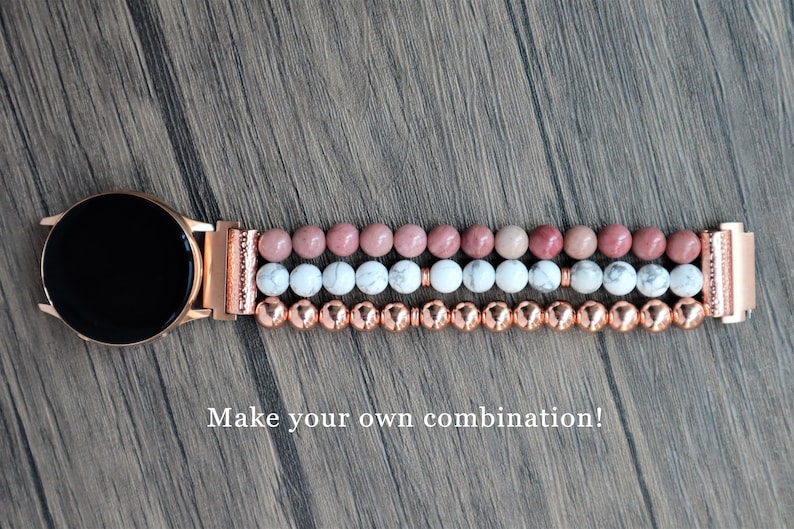May include: A rose gold smartwatch band with three rows of beads. The top row is pink, the middle row is white, and the bottom row is copper. "Make your own combination!" is written below the band.