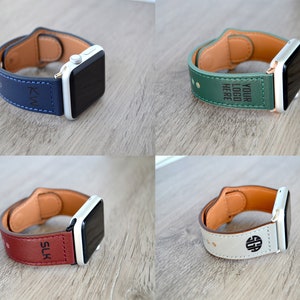 May include: Four different Apple Watch bands with personalized engravings. The bands are made of leather and come in blue, green, red, and white.