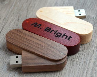 May include: Three wooden USB flash drives stacked on top of each other. The top drive is light wood, the middle drive is red, and the bottom drive is dark wood. The red drive has the text "M. Bright" engraved on it.