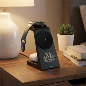 May include: Black charging station with a built-in stand for a smartwatch, wireless charging pad, and space for earbuds. The station has the name "MICHAEL" engraved on it. A blue light is illuminated at the base.
