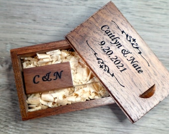 May include: A wooden box with a personalized inscription reading "Caitlyn & Nate 9.20.2021" and a small wooden USB drive inside. The box is filled with wood shavings.