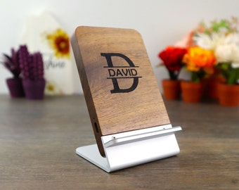 Könnte beinhalten: Ein Holz-Handyladeständer mit einem silbernen Metallfuß. Der Ständer ist mit einer personalisierten Gravur versehen, die "D DAVID" lautet.