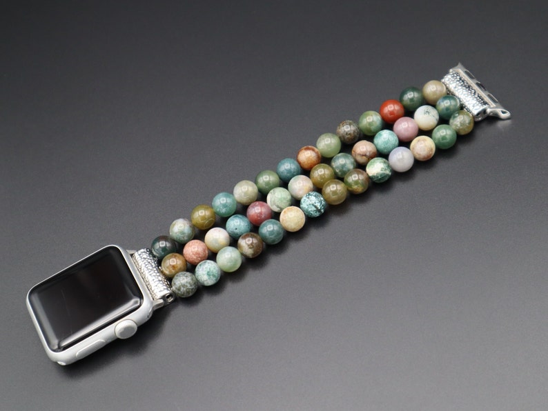 Puede incluir: Una pulsera de reloj de cuentas de &aacute;gata multicolor con cierre de plata. La pulsera est&aacute; hecha de cuentas redondas en tonos verdes, marrones y rosas.