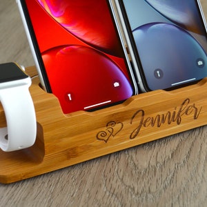 May include: A wooden charging station with two slots for phones and a slot for a watch. The station is engraved with the name "Jennifer" and a heart design.