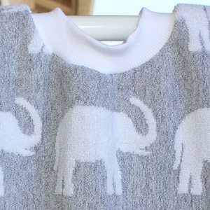 May include: A gray hooded towel with a white trim and a white elephant pattern.