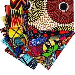 May include: A collection of colorful African wax print fabrics. The fabrics feature a variety of geometric and abstract patterns in vibrant colors like yellow, red, blue, and green. The fabrics are folded and stacked, showcasing the diverse designs.