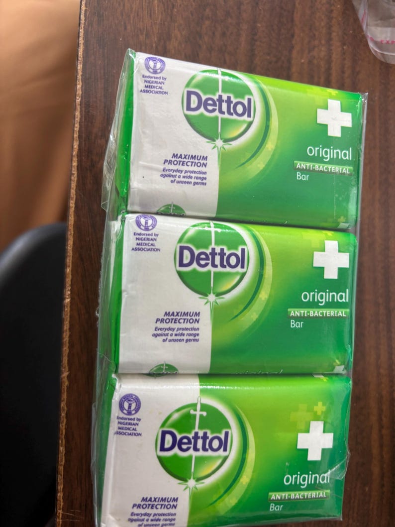 May include: A three-pack of Dettol Original anti-bacterial soap bars wrapped in clear plastic. Each green and white package features the Dettol logo, a white cross, and the text Maximum Protection, Everyday protection against a wide range of unseen germs.