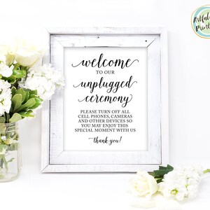 May include: A white framed sign with black text that reads "Welcome to our unplugged ceremony. Please turn off all cell phones, cameras and other devices so you may enjoy this special moment with us. Thank you!"