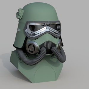 May include: A green and black helmet with a gas mask and a visor. The helmet has a textured surface and a small detail on the top.