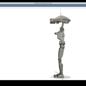 K&ouml;nnte beinhalten: Ein grauer, artikulierter Roboter mit einem runden, flachen Kopf und einer einzelnen Antenne. Der Roboter steht auf einer wei&szlig;en Oberfl&auml;che.