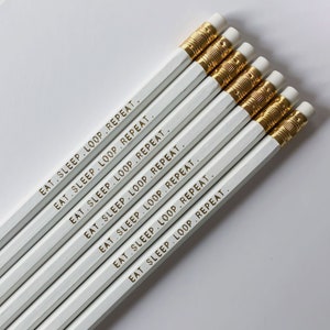 Eat Sleep Loop Repeat と書かれた鉛筆セット - 白地に金色のエンボス文字 - 編み物やかぎ針編みをする人へのギフト