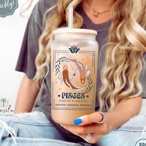 May include: A frosted glass tumbler with a bamboo lid and a straw. The tumbler features a graphic of two fish with the text "Pisces (February 19-March 20) Creative Generous Intuitive".