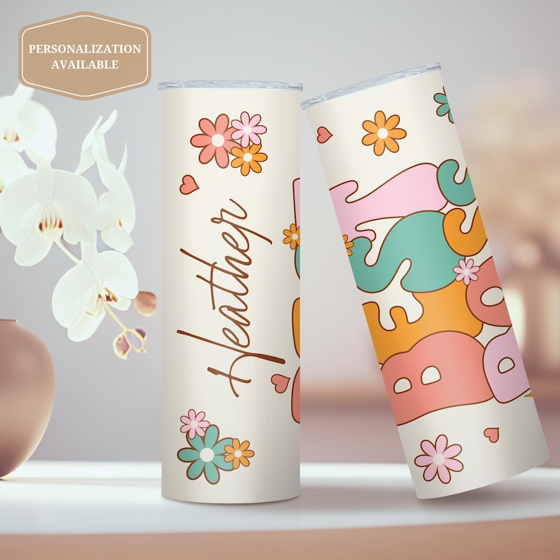 May include: Two personalized stainless steel tumblers with a retro flower and heart design. One tumbler says "Heather" and the other says "Best" in a colorful, retro font.