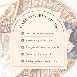 May include: A beige card with the words "CARE INSTRUCTIONS" in a curved font. The card lists care instructions with checkmarks, including using mild detergent, pre-treating stains, washing inside-out, gentle cold cycle, and tumble dry low or hang to dry.