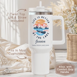 K&ouml;nnte beinhalten: Wei&szlig;er 1,18L-Becher mit Komfortgriff. Der Becher zeigt eine Seeszene mit dem Text "LIFE IS BETTER AT THE LAKE" und dem Namen "Jessica". Inklusive Drehverschluss und Strohhalm. Passt in die meisten Getr&auml;nkehalter.