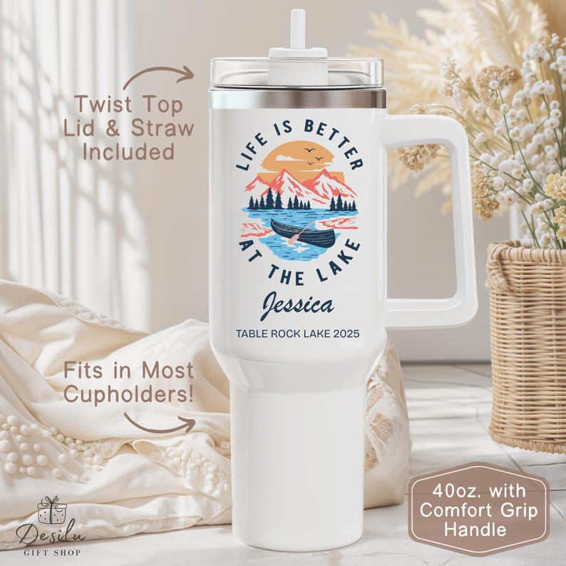 K&ouml;nnte beinhalten: Wei&szlig;er 1,18L-Becher mit Komfortgriff. Der Becher zeigt eine Seeszene mit dem Text "LIFE IS BETTER AT THE LAKE" und dem Namen "Jessica". Inklusive Drehverschluss und Strohhalm. Passt in die meisten Getr&auml;nkehalter.