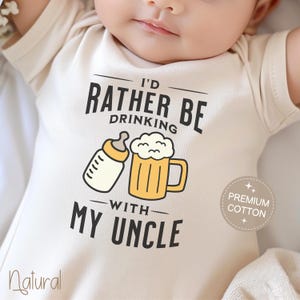 May include: A white baby onesie with the text "I'd rather be drinking with my uncle" and a graphic of a baby bottle and a beer mug.