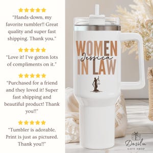Pu&ograve; includere: Bicchiere bianco con manico, con la scritta "WOMEN IN LAW Jessica" in lettere marroni e beige. Una silhouette di una persona che tiene una bilancia &egrave; sotto il testo. Il bicchiere ha un coperchio bianco e una cannuccia.