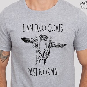 May include: A gray t-shirt with the text "I am two goats past normal" and a black and white illustration of a goat's head.