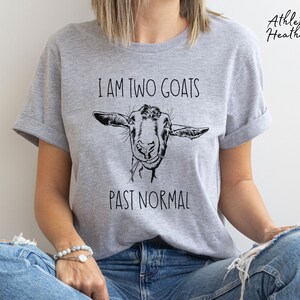 May include: A gray t-shirt with the text "I am two goats past normal" and a black and white illustration of a goat's head.