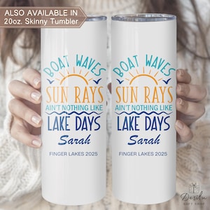 K&ouml;nnte beinhalten: Zwei wei&szlig;e 590ml Skinny-Becher mit einem Design mit den Worten "Boat Waves, Sun Rays, Lake Days" in Blau und Orange. Der Name "Sarah" und "Finger Lakes 2025" sind ebenfalls aufgedruckt.