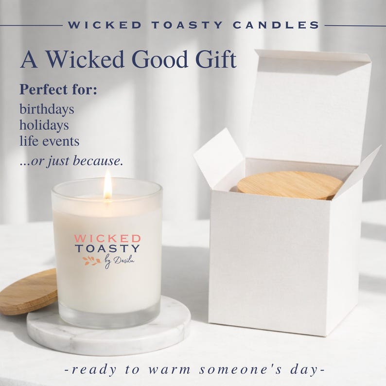Może przedstawiać: Świeca w przezroczystym szkle z zapalonym knotem i białym woskiem, z napisem WICKED TOASTY by Desilu w kolorze r&oacute;żowym i niebieskim. Zestaw zawiera okrągłą drewnianą pokrywkę oraz białe kartonowe pudełko prezentowe z pasującą pokrywką.