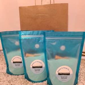 May include: Three blue resealable bags filled with bath salts. Each bag has a white circular label with the text "Dream in Soap by... I Want To Breathe! Fizz & Foam Bath Soak".