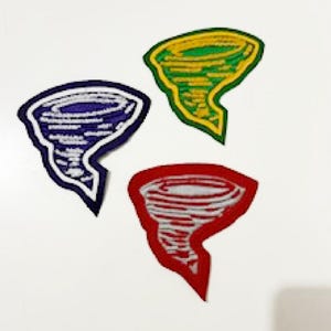 May include: Three embroidered patches in the shape of a tornado. One is blue with a white outline, another is green with a yellow outline, and the third is red with a white outline. The patches are on a white background.