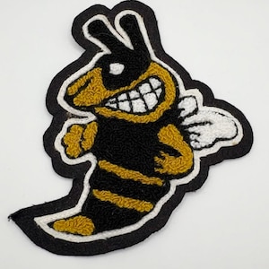 May include: Embroidered patch featuring a cartoon-style bee with a smiling face and white teeth. The bee has a black body with yellow stripes and accents, white wings, and is outlined in black with a white border. This patch is suitable for jackets, bags, or other fabric items.