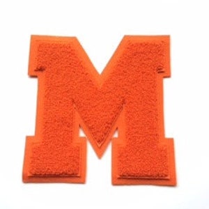 May include: Orange chenille letter "M" patch with a felt border. The varsity-style patch is a bold, block letter design, perfect for jackets, bags, or other fabric items. The patch is set against a white background.
