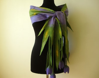 May include: A purple and green felted wool scarf with a fringed edge and a flower design. The scarf is tied around a black mannequin.