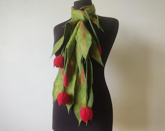 May include: A felt scarf in green with red accents and red tulip-shaped embellishments. The scarf is draped on a black mannequin, showcasing its design. The scarf's leaves have a textured appearance.